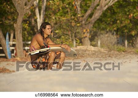Picture - Surfer along Mal Pais coastline in San Jose Costa Rica. Fotosearch