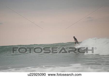 Surfer along Mal Pais coastline in San Jose Costa Rica View Large Photo Image Stock Image - Surfer along Mal Pais coastline in San Jose Costa Rica. Fotosearch