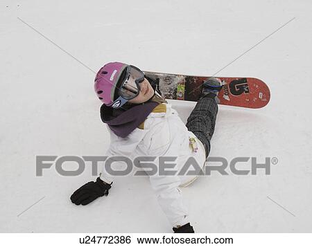 Stock Photograph - Teenage girl sitting in the snow on a ski slope of Vail Colorado. Fotosearch