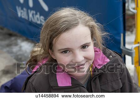 Picture - Ten year old blond girl smiling at the camera in Vail, Colorado. Fotosearch