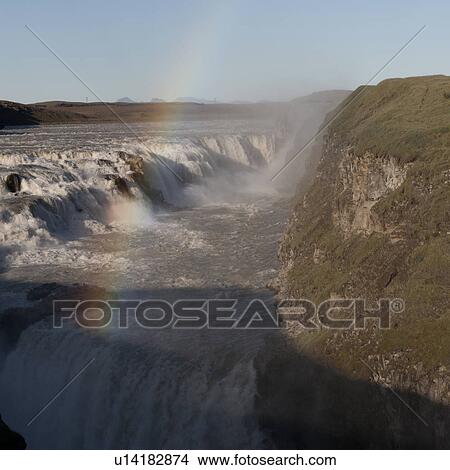 Tiered waterfall with grassed cliff and rainbow View Large Photo Image Picture - Tiered waterfall with grassed cliff and rainbow. Fotosearch