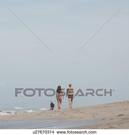 Picture - Two women walking on the beach in Costa Rica. Fotosearch