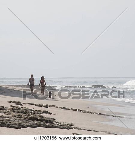 Stock Photograph - Two women walking on the beach in Costa Rica. Fotosearch