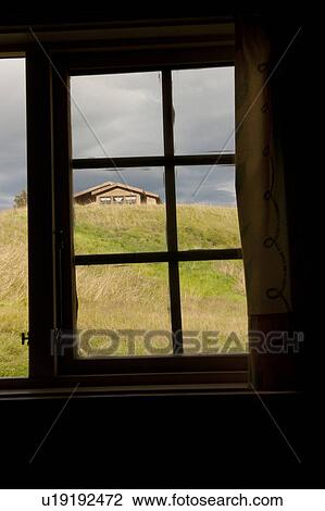 Stock Image - View of a rural house through a window pane in South Iceland. Fotosearch