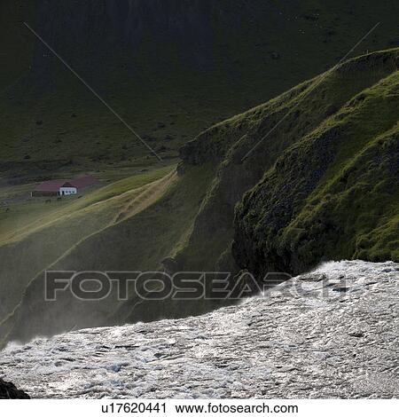 Stock Image - Waterfall cascade in verdant grassland. Fotosearch