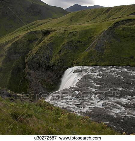 Waterfall cascade in verdant grassland View Large Photo Image Stock Photo - Waterfall cascade in verdant grassland. Fotosearch