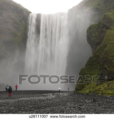 Waterfall cascade over cliff to riverbed and sightseers View Large Photo Image Stock Photo - Waterfall cascade over cliff to riverbed and sightseers. Fotosearch