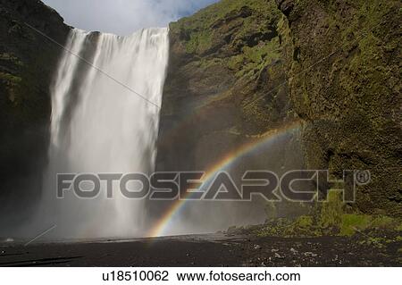 Waterfall cascading over a green rock cliff, with a double rainbow coming from the mist from the lake View Large Photo Image Stock Image - Waterfall cascading over a green rock cliff, with a double rainbow coming from the mist from the lake. Fotosearch