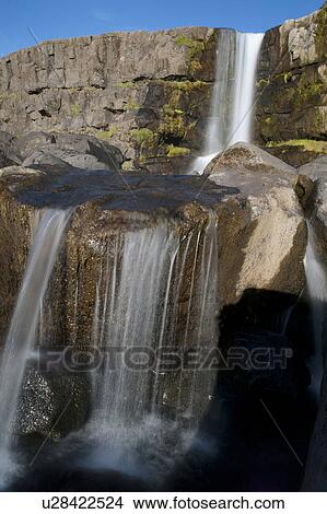 Waterfall over rocky cliffs in Iceland View Large Photo Image Picture - Waterfall over rocky cliffs in Iceland. Fotosearch