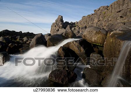 Waterfall through rugged terrain of rock and boulders View Large Photo Image Stock Photograph - Waterfall through rugged terrain of rock and boulders. Fotosearch