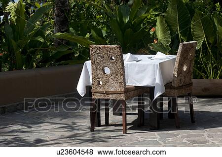 Stock Photo - White tablecloth formal dining setting outside on the terrace. Fotosearch