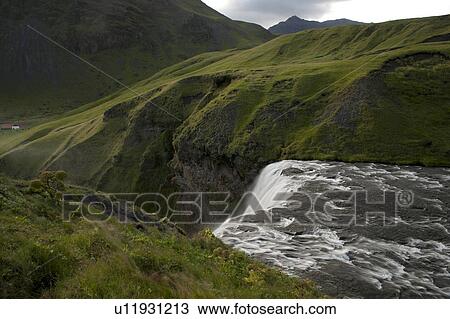 White water flowing over a cliff surrounded by green meadows in the mountains View Large Photo Image Stock Image - White water flowing over a cliff surrounded by green meadows in the mountains. Fotosearch