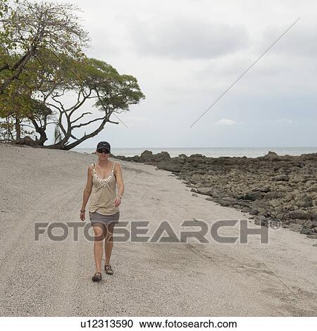 Woman walking along coastal road in Costa Rica View Large Photo Image Stock Image - Woman walking along coastal road in Costa Rica. Fotosearch