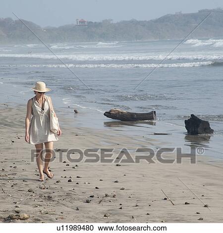 Stock Image - Woman walking along the Seashore in Costa Rica. Fotosearch