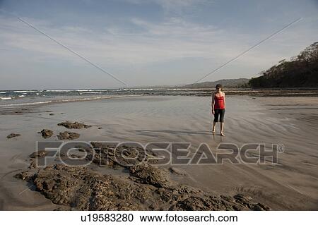 Stock Image - Woman walking on the beach, San Jose Costa Rica. Fotosearch