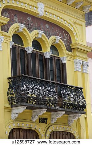 Stock Photo - Yellow two storey building with wrought iron balcony and arched windows . Fotosearch