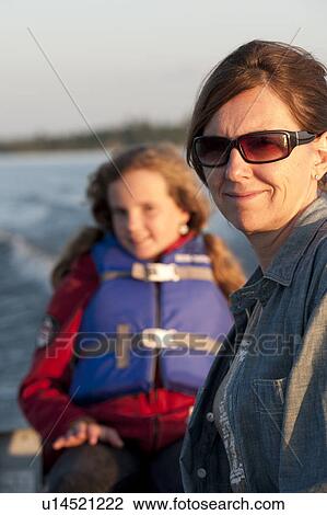 Young girl in a boat wearing a life jacket at Lake of the Woods, Ontario View Large Photo Image Stock Image - Young girl in a boat wearing a life jacket at Lake of the Woods, Ontario. Fotosearch