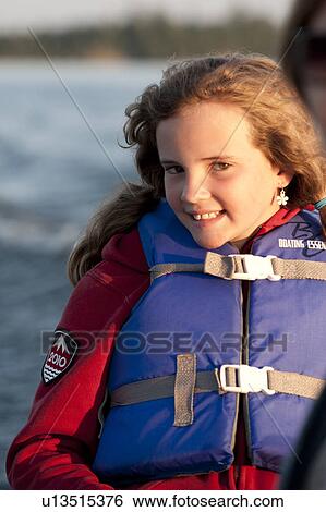 Young girl in a boat wearing a life jacket at Lake of the Woods, Ontario View Large Photo Image Stock Photograph - Young girl in a boat wearing a life jacket at Lake of the Woods, Ontario. Fotosearch