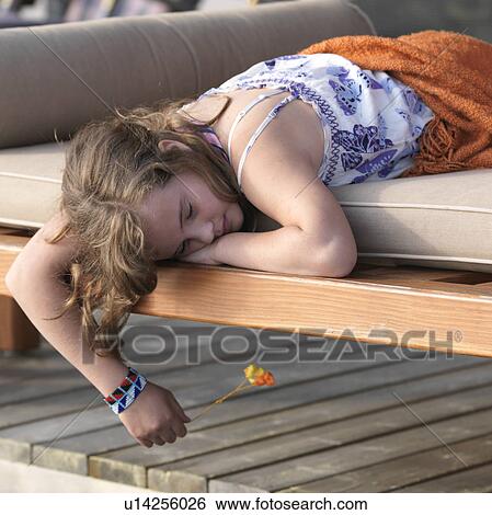 Young girl laying on a lounge cushion at Lake of the Woods, Ontario View Large Photo Image Stock Photograph - Young girl laying on a lounge cushion at Lake of the Woods, Ontario. Fotosearch