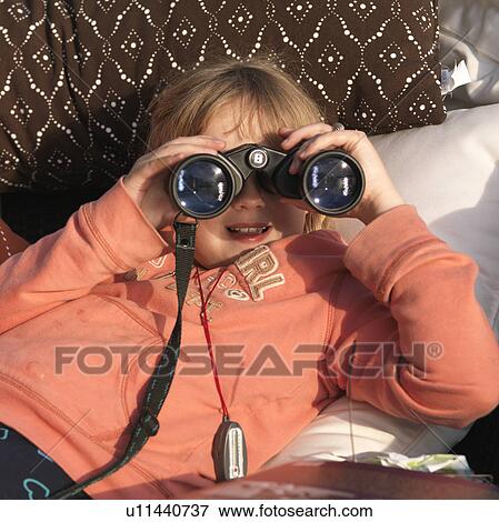 Stock Photo - Young girl looking through binoculars at Lake of the Woods, Ontario. Fotosearch