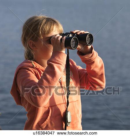 Young girl looking through binoculars at Lake of the Woods, Ontario View Large Photo Image Stock Photo - Young girl looking through binoculars at Lake of the Woods, Ontario. Fotosearch