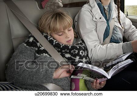 Young girl reading a book in the car wearing a seatbelt View Large Photo Image Stock Image - Young girl reading a book in the car wearing a seatbelt. Fotosearch