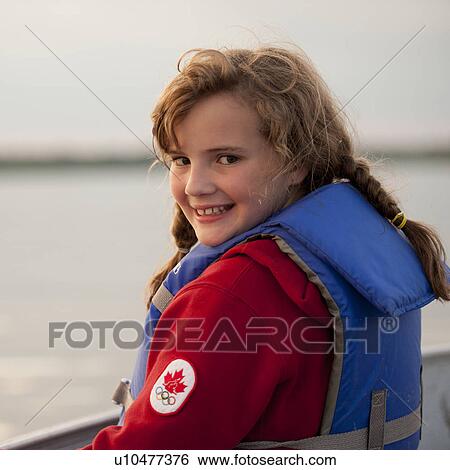 Young girl wearing a life jacket looking at the camera View Large Photo Image Stock Photograph - Young girl wearing a life jacket looking at the camera . Fotosearch