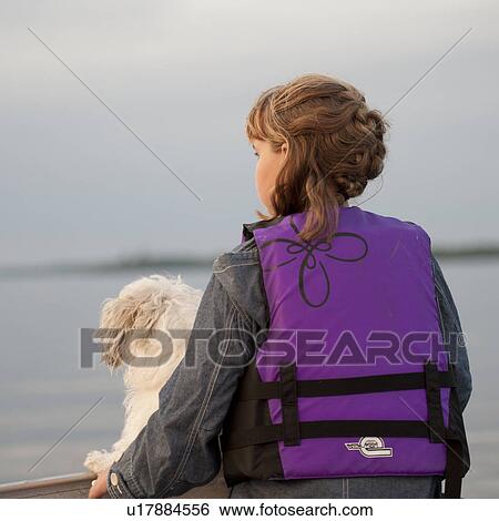 Young girl wearing a life jacket with her dog in Lake of the Woods, Ontario View Large Photo Image Stock Photograph - Young girl wearing a life jacket with her dog in Lake of the Woods, Ontario. Fotosearch