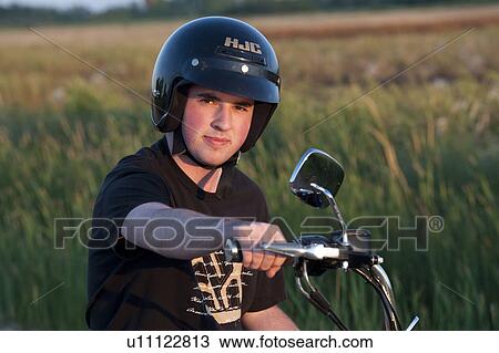 Young man wearing a helmet on a motorcycle View Large Photo Image Stock Image - Young man wearing a helmet on a motorcycle. Fotosearch