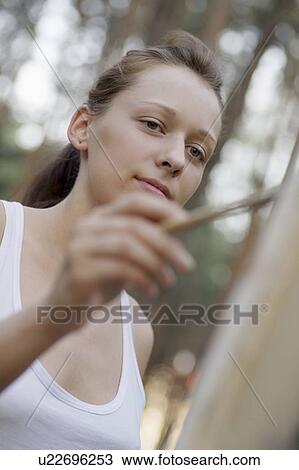 Artists stands painting on canvas View Large Photo Image Stock Image - Artists stands painting on canvas. Fotosearch