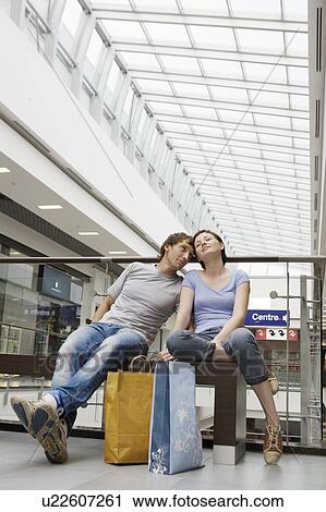 Stock Image - Coule sit with shopping bags in Voronezh. Fotosearch