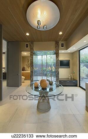 Stock Image - Glass topped table in reception room of California home. Fotosearch
