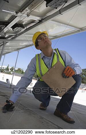 Stock Image - Maintenance worker checking solar panel in Los Angeles, California. Fotosearch