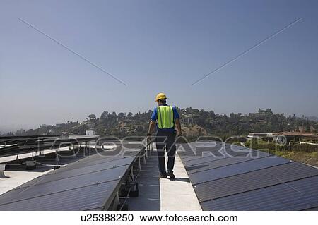 Maintenance worker checks solar array on rooftop in Los Angeles, California View Large Photo Image Stock Image - Maintenance worker checks solar array on rooftop in Los Angeles, California. Fotosearch