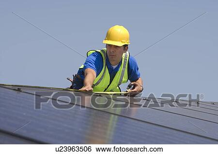 Maintenance worker measures solar array on rooftop, Los Angeles, California View Large Photo Image Stock Photograph - Maintenance worker measures solar array on rooftop, Los Angeles, California. Fotosearch