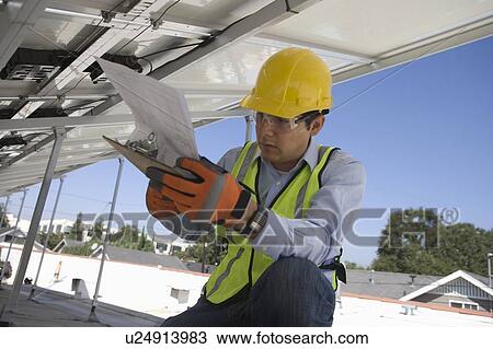 Maintenance worker refers to notes under solar panel in Los Angeles, California View Large Photo Image Stock Image - Maintenance worker refers to notes under solar panel in Los Angeles, California. Fotosearch