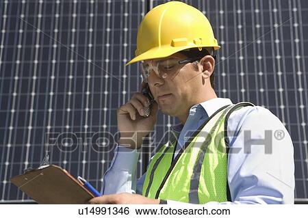Stock Photograph - Maintenance worker with photovoltaic array in Los Angeles, California. Fotosearch