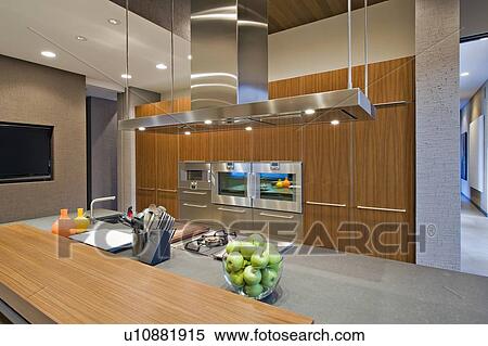 Stock Photography - Wood panelled spotlit kitchen in California home. Fotosearch