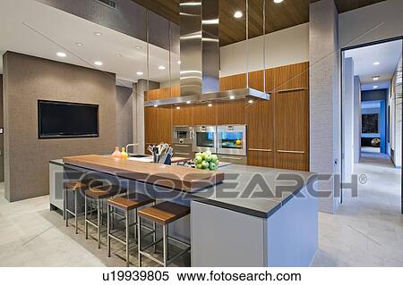 Stock Photography - Wood panelled spotlit kitchen in California home. Fotosearch