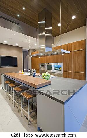 Stock Photography - Wood panelled spotlit kitchen in California home. Fotosearch