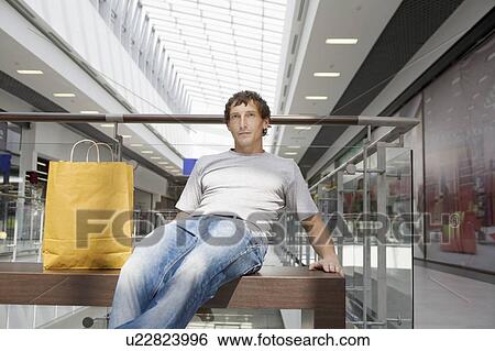 Young man sits in new shopping centre, Voronezh View Large Photo Image Stock Photograph - Young man sits in new shopping centre, Voronezh. Fotosearch
