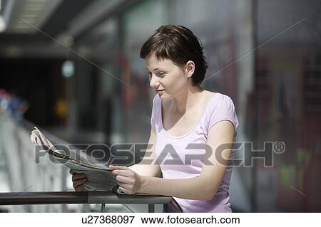 Young woman reading newspaper in shopping centre, Voronezh View Large Photo Image Stock Photo - Young woman reading newspaper in shopping centre, Voronezh. Fotosearch