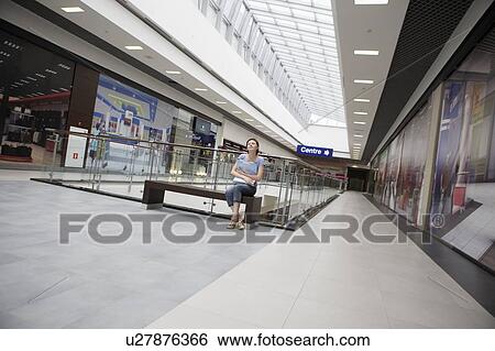 Stock Photograph - Young woman sits in new Voronezh shopping centre. Fotosearch