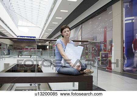 Stock Photography - Young woman sits in new Voronezh shopping centre. Fotosearch