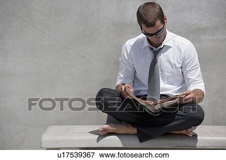 Barefoot businessman sitting on bench reading newspaper View Large Photo Image Stock Photo - Barefoot businessman sitting on bench reading newspaper. Fotosearch