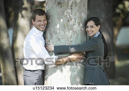Business people outdoor hugging a tree View Large Photo Image Picture - Business people outdoor hugging a tree. Fotosearch