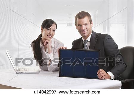 Stock Photo - Businessman and woman with solar panel. Fotosearch