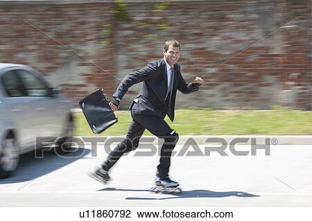 Businessman in suit inline skating View Large Photo Image Stock Image - Businessman in suit inline skating. Fotosearch