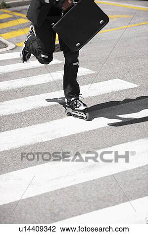 Businessman in suit inline skating across road View Large Photo Image Stock Image - Businessman in suit inline skating across road. Fotosearch