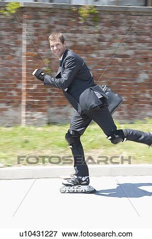 Stock Photo - Businessman in suit inline skating. Fotosearch